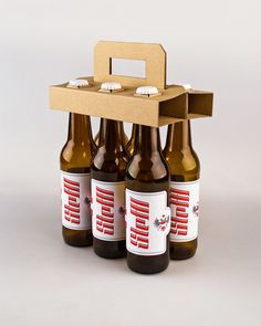 four beer bottles are stacked on top of each other in front of a cardboard box