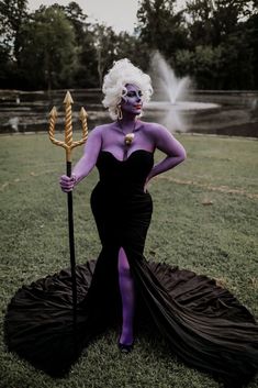 a woman dressed in black and purple poses for a photo