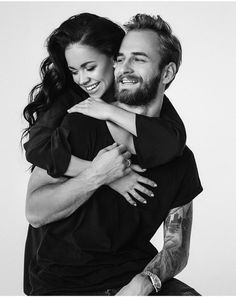 a man and woman hugging each other in black and white