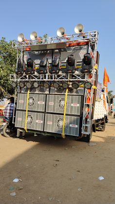 an electronic device is sitting on the back of a truck in front of some people