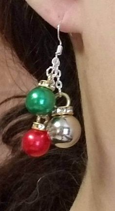 a close up of a person wearing earrings with bells and balls on it's ear