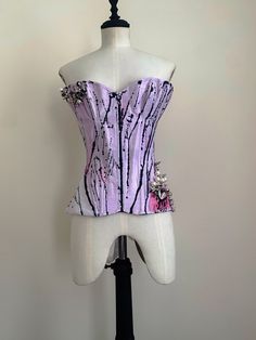 22" waist, double layer, steel boned overbust corset; with in my signature hip panels, and mesh heart cutouts on one side. Features metal spike and faux pearl embellishment, reminiscent of the arrangement of the structure of virus cells (hence the name); applied onto hand died lilac silk dupion, painted to look like butterfly wings. This sample is slightly bigger at the bust, so you may wish to message to double check measurements prior to purchase! This corset is a reworking of an old design, a Punk Party Corset With Corset Back, Punk Style Party Corset With Corset Back, Punk Overbust Corset Dress With Boned Bodice, Punk Style Overbust Corset Dress With Boned Bodice, Punk Style Corset With Boned Bodice For Costume Party, Punk Boned Bodice Corset For Costume Party, Fitted Punk Style Corset For Parties, Punk Party Corset With Boned Bodice, Punk Style Party Corset With Boned Bodice