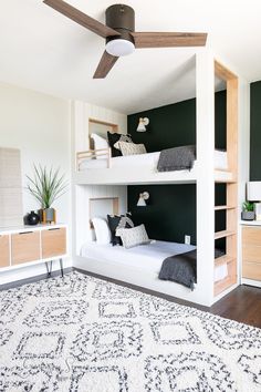 a bedroom with two bunk beds and a rug on the floor in front of it