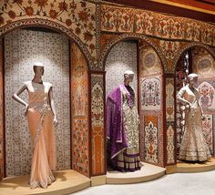 several mannequins are displayed in an ornate display case