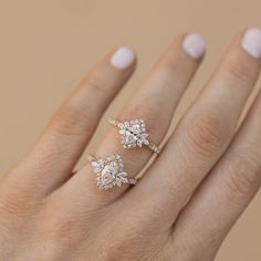 a woman's hand with two engagement rings on it