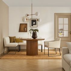 a dining room table with chairs and a couch in front of it, next to a window