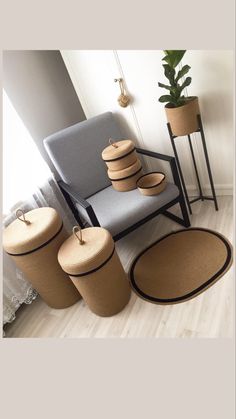 a chair and some baskets on the floor next to a potted plant in a room