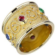 S.Georgios design ring is handcrafted from solid 18 Karat Yellow Gold and is microscopically decorated all the way around with gold beads and wires shaped like the last letter of the Greek Alphabet - Omega, which symbolizes eternal life. Granulated details contrast with a unique byzantine velvet background. This gorgeous piece features 2 brilliant-cut Rubies total weight of 0.24 Carat, 2 brilliant-cut emeralds, a total weight of 0.21 Carat, and 2 brilliant-cut sapphires, the total weight of 0.23 Ruby Band Ring, Tiffany Engagement Ring, Ruby Bands, Gold Diamond Band, Platinum Diamond Engagement Rings, Hot Jewelry, Silver Jewelry Design, Wide Band Rings, Diamond Rings Bands