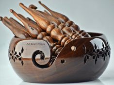 a wooden bowl filled with lots of wood utensils