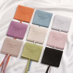 six different colors of ties laid out on top of a white sheet with the names of each