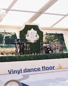 the stage is set up for an event with musical instruments and greenery on it