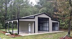 a large metal building sitting in the middle of a forest