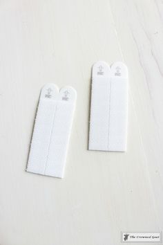 two pieces of white cloth sitting next to each other on a wooden table with one piece cut out