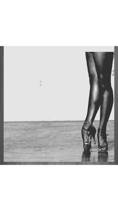 a black and white photo of a woman's legs in high heeled shoes