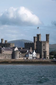 an old castle sits on the edge of a body of water