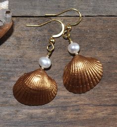 "Stylish earrings with beautiful gold painted seashells and white freshwater pearls. 18K gold plated nickel-, lead- and cadmium-free stainless steel hooks. Measure about 30mm (1,2\") from the lower part of the hook. These earrings will come in a pretty organza gift bag ready for gifting! If you have any questions just convo me and I will get back to you as soon as possible. Thanks for looking // Mari" Elegant Gold Pearl Earrings For Summer, Elegant Nickel-free Shell Jewelry, Elegant Gold Shell-shaped Jewelry, Gold Pearl Drop Earrings In Mother Of Pearl, Gold Shell Dangle Earrings, Summer Gold Pearl Drop Earrings, Elegant Shell-shaped Brass Jewelry, Gold Pearl Earrings As Summer Gift, Gold Pearl Earrings For Summer Gifts