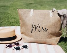 a hat, sunglasses and bag sitting on top of a blanket