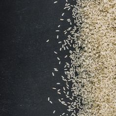 white rice and brown rice on a black surface