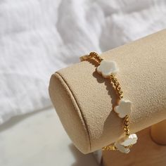 Handmade 18k gold plated beaded bracelet with white flower beads & 18k Gold plated toggle fastening. LINK TO MATCHING NECKLACE: https://www.etsy.com/uk/listing/1518399118/gold-necklace-with-flower-shell-pendant?click_key=60d799fbbe65c5320437f45483e0935f8307c039%3A1518399118&click_sum=7314c1eb&ref=shop_home_active_1&sca=1 LINK TO MATCHING EARRINGS: https://www.etsy.com/uk/listing/1532577691/white-flower-huggie-hoop-earrings-in-18k?click_key=33181415c117a66f428dc884de94a85e4b55527f%3A1532577691&click_sum=698cebe7&ref=shop_home_active_2&sca=1 Designed & Handmade in the UK Available in 2 sizes:  - Small (7 inches) - Large (8 inches) DELIVERY & PACKAGING: All our pieces come beautifully presented in a hand printed drawstring pouch. You can add a gift message free of charge at checkout. All our Dainty White Beaded Bracelets With Adjustable Chain, Elegant White Bracelets With Flower Charm, Elegant Gold Beaded Bracelet With Flower Charm, White Dainty Bracelets With Adjustable Chain, Adjustable White Gold-plated Beaded Bracelets, Adjustable White Gold Plated Beaded Bracelets, Delicate White Flower-shaped Bracelet, White Adjustable Chain Bracelet, White Dainty Adjustable Chain Bracelet