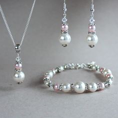 Bicolour 3-piece jewellery set featuring Swarovski pearls (colours: white and rosaline) combined with shimmering rhinestones and Swarovski crystals. Perfect for any occasion, weddings and parties or as a gift. Set contains a pendant necklace with a delicate silver plated chain, beaded bracelet and a pair of drop earrings.  Organza gift bag included! Please note that although I take a great care to keep the colours on the photographs as close to reality as possible, they may look slightly differe Pink Pearl Bracelet For Wedding, Silver Pearl Jewelry For Bridesmaid Gift, Pink Pearl Drop Bracelet For Wedding, Pearl White Crystal Jewelry For Mother Of The Bride, Pearl White Round Beads Jewelry For Bridesmaid Gift, Pink Pearl Jewelry Sets For Gifts, Pink Pearl Jewelry Sets As Gift, Pink Pearl Wedding Jewelry, Pearl Wedding Jewelry Sets