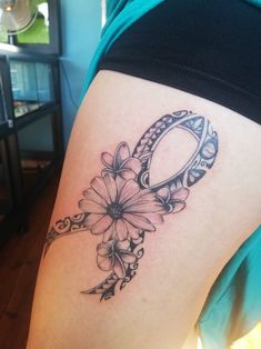 a woman's thigh with a tattoo on it that has flowers in the shape of an o