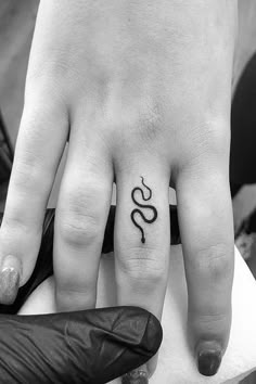 two people with tattoos on their fingers and one is holding the other's hand