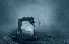 a person standing in the fog next to a tombstone