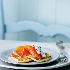 a white plate topped with pancakes covered in salmon