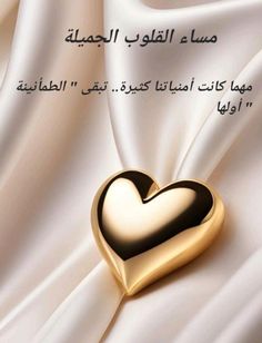 a gold heart on white silk with arabic writing in the middle and an image of two hearts