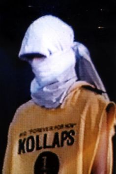 a person wearing a yellow shirt with a white mask on their head and the words kollaps printed on it