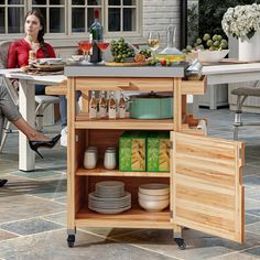 a woman sitting at a kitchen island with plates and glasses on it next to a table full of food