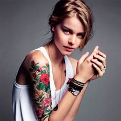 a woman with tattoos on her arm posing for the camera