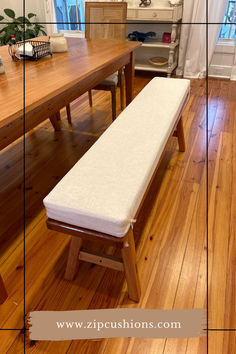 a wooden bench sitting on top of a hard wood floor next to a dining room table