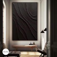 a living room with a large black painting on the wall and wooden flooring in front of it