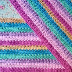 a crocheted blanket that is laying on top of each other in different colors