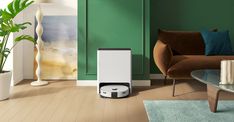 a living room with green walls and a white air purifier on the floor