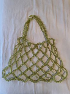 This olive green hand beaded shopper tote is the perfect chore bag or beach bag for summer months. It has plenty of space for all you need throughout the day, and you get to have a cute accessory while you're at it ;) Each tote is hand made in Seattle, so you'll get a truly one of a kind bag just for you. It takes about 2 weeks to make each bag, and then they'll be on their way to you!  The totes are 14in tall, 21in wide at the base and 14in wide at the top, and have 11.5in handles, so it'll fit comfy on your shoulder (measurements taken laying flat).  There is a small bit of stretch to the bag, so there's plenty of room for whatever you might need. Summer Beaded Rectangular Beach Bag, Green Crochet Bag For Beach Shopping, Green Crochet Bag For Beach Season Shopping, Green Bohemian Crochet Shopping Bag, Bohemian Green Crochet Shopping Bag, Square Beaded Shoulder Bag For Beach, Beaded Crochet Beach Bag For Summer, Summer Beach Crochet Bag With Beaded Detail, Summer Beach Beaded Crochet Bag