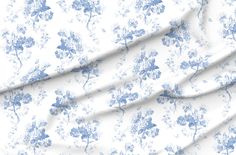 a white and blue flowered fabric with a ruler in the foreground, on a white background