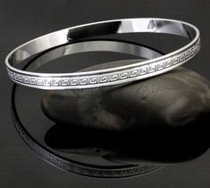 All of our endless bangles start as high quality jeweler's brass seamless rings which we hand emboss, one at a time. Each piece is then finished with a high grade silver plate. They are extremely durable and will retain their beauty for years. Symbolic Engraved Round Bangle, Etched Metal Bangle As Gift, Greek Key, Emboss, High Grade, Silver Plate, Bangle Bracelets, Silver Bracelet, Jewelry Bracelets