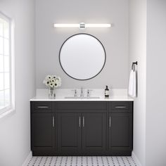 a bathroom with two sinks and a round mirror on the wall above it's counter