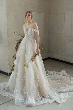 a woman in a wedding dress with flowers on the floor