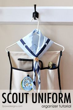 the scout uniform is hanging on a coat rack with an ironing board attached to it