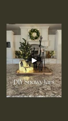 a kitchen counter top with a christmas tree and decorations in the center, and an ad that reads diy snow jars