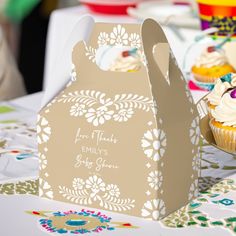 cupcakes in paper bags sitting on a table at a birthday party with decorations