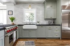 a kitchen with gray cabinets and stainless steel appliances