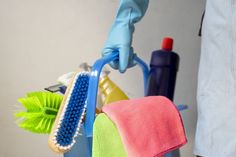 a person in blue gloves is holding a brush and cleaning sponges on a mop