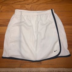 White Nike Sports Skirt With Black Outline Nike Sporty White Skirt, Nike White Lined Skirt, Nike White Summer Skirt, Nike White Casual Skort, Nike White Tennis Skirt For Spring, Nike White Skirt For Summer, Nike White Skirt For Spring, White Athleisure Short Skirt, White Short Athleisure Skirt