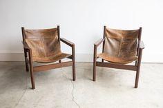 two leather chairs sitting next to each other