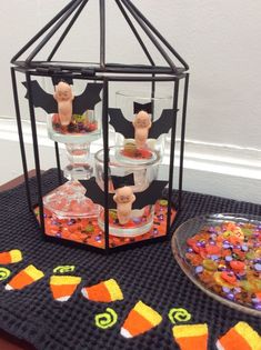 halloween treats in glass containers on a table with candy and candies around the edges