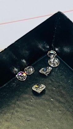 three diamond pendants are sitting on a black tray